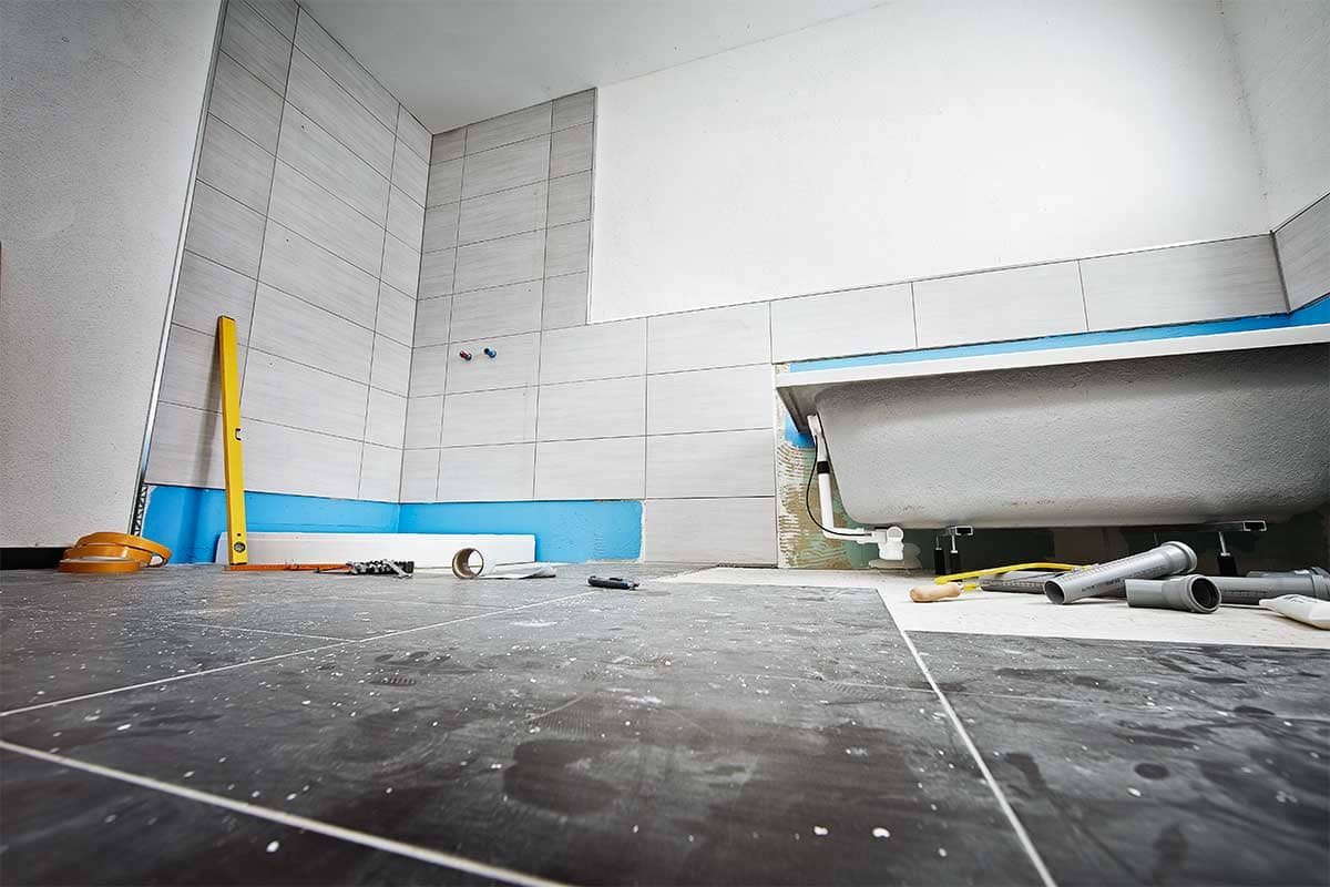 Badkamer in aanbouw met bad, tegels en gereedschap
