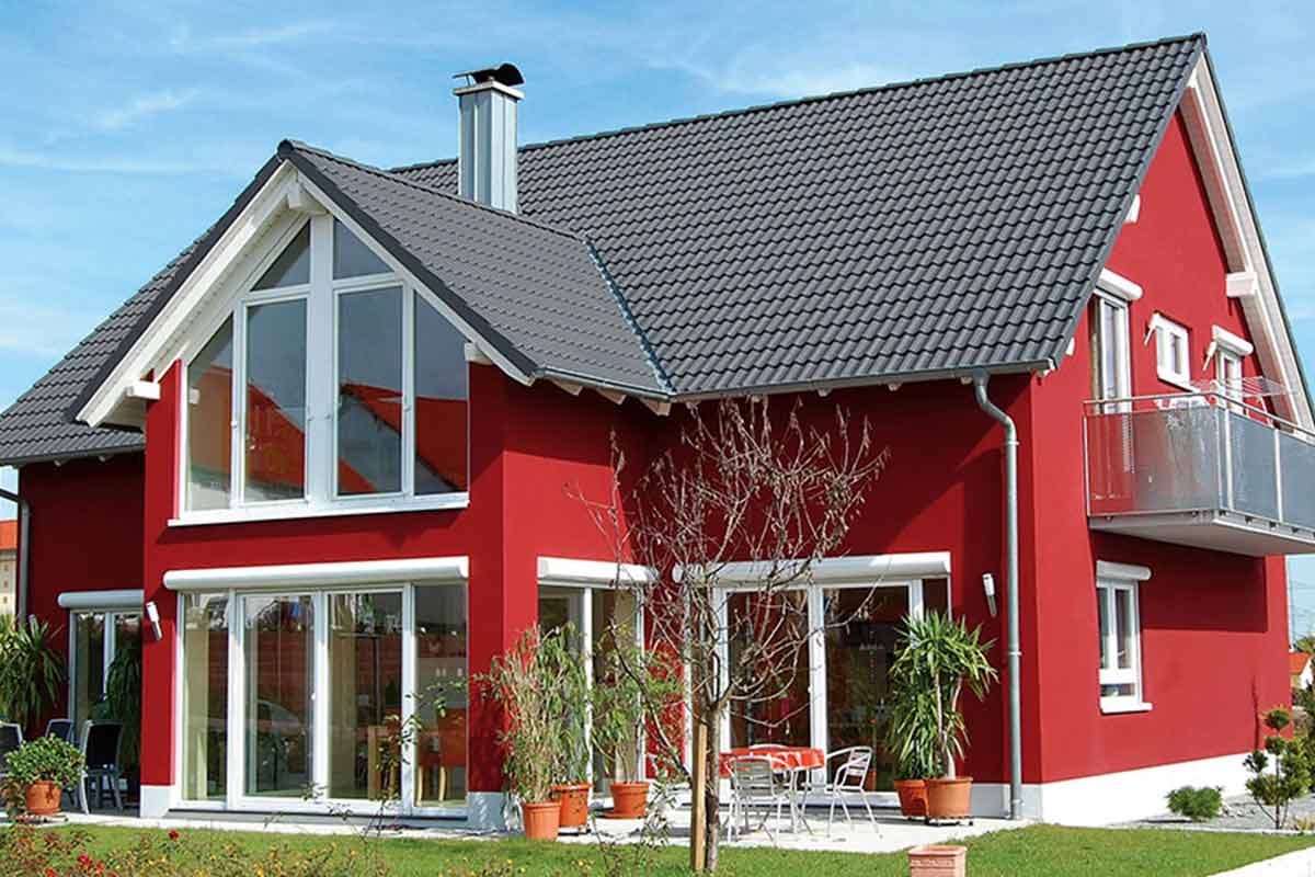 Exterieur van een woonhuis met een pannendak, luiken en tuin