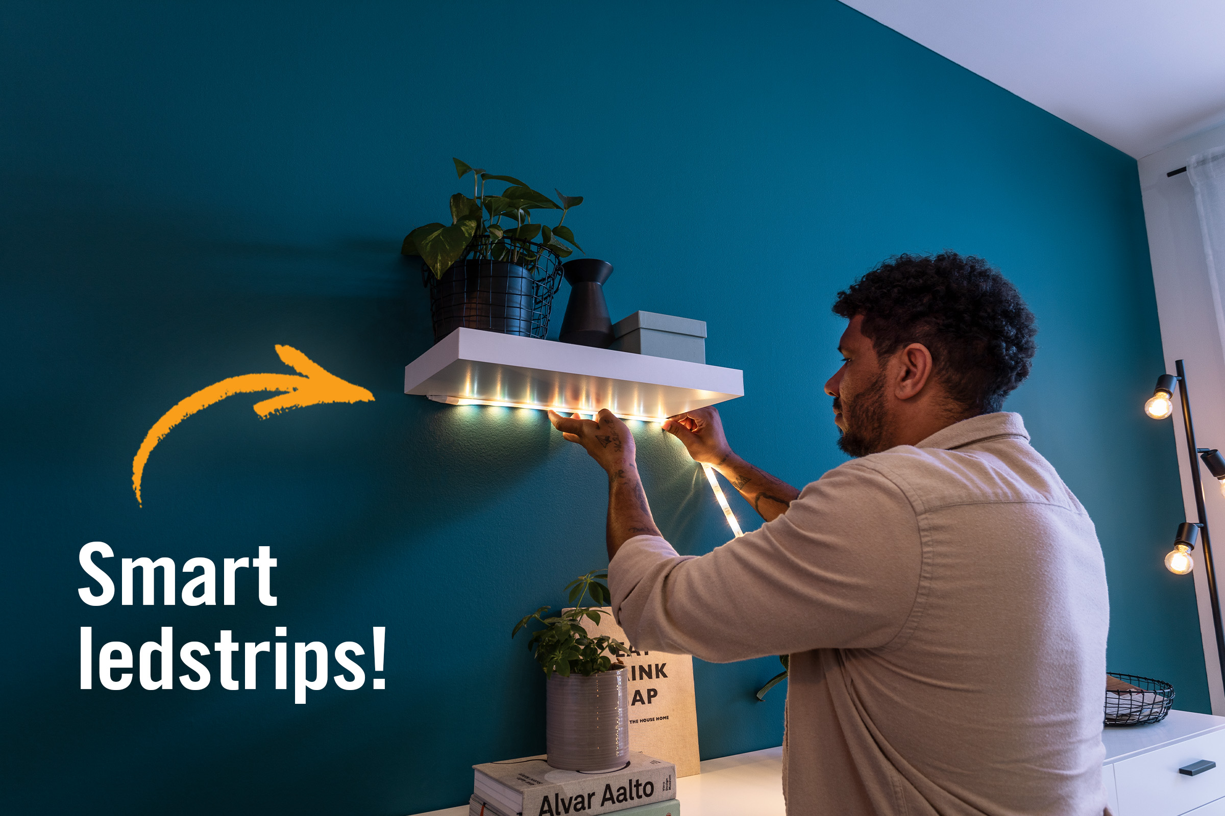 Man bevestigt ledstrips onder een plank in de woonkamer.