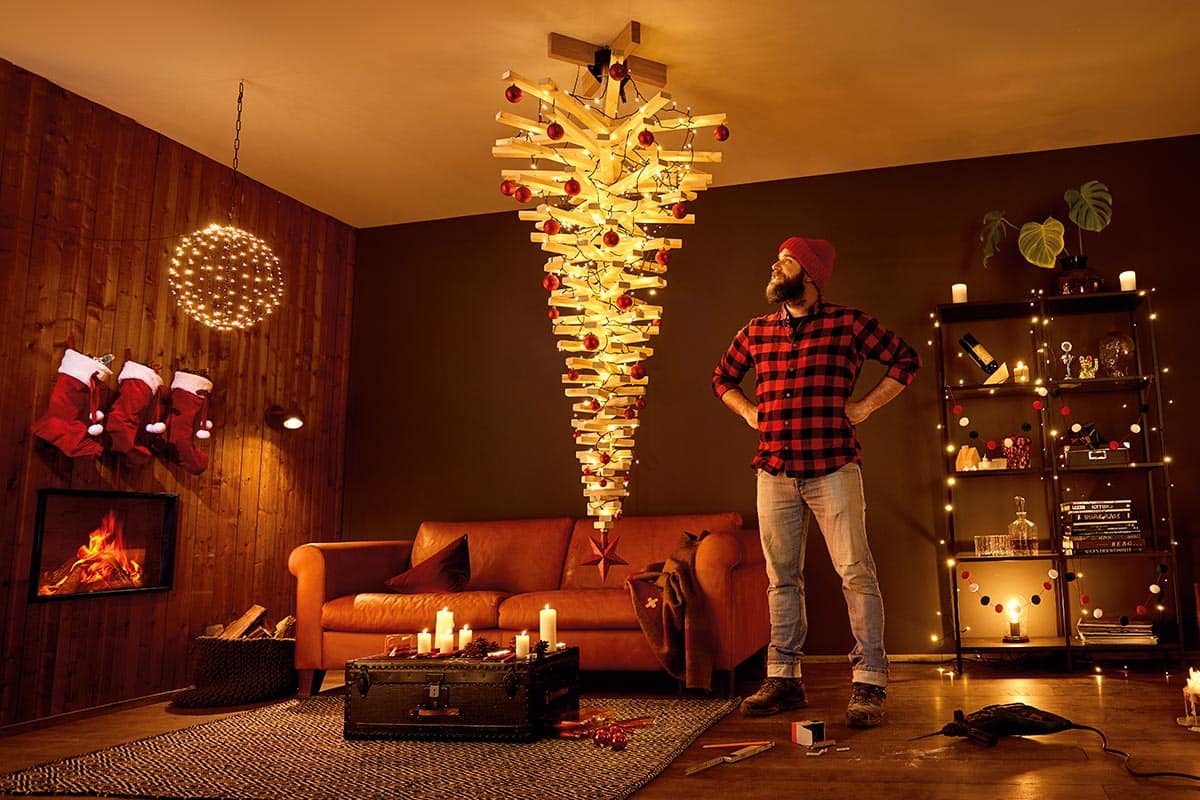 Woonkamer met hangende houten kerstboom, versierd met lichtjes en ballen