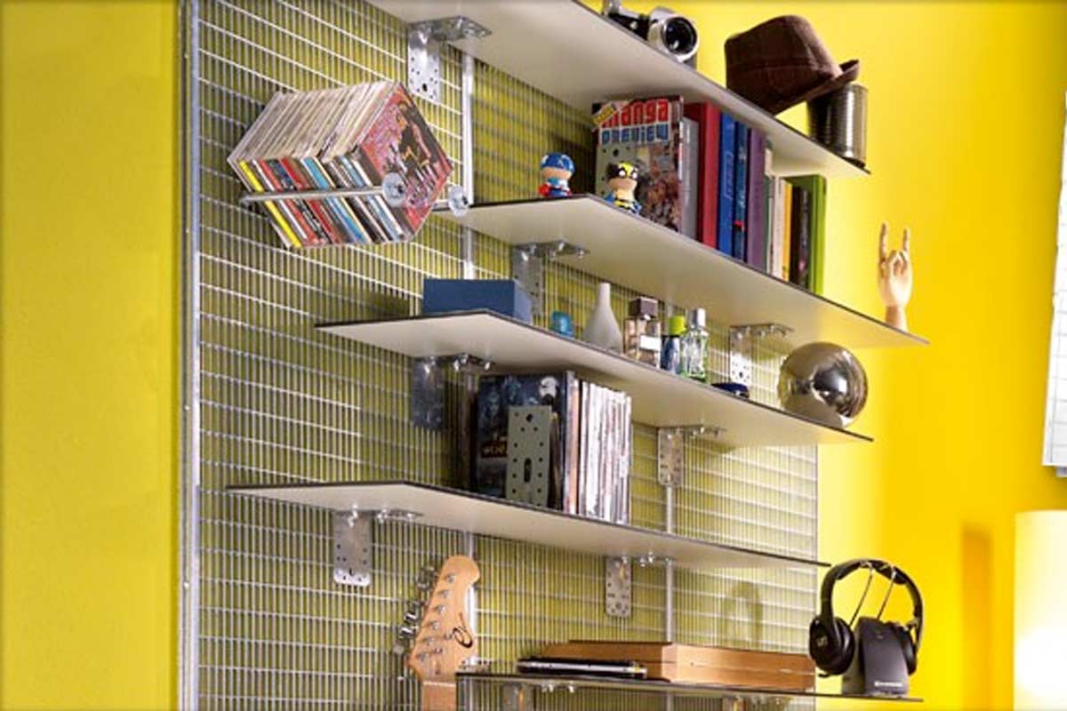 Rek systeem met planken aan een metalen rasterwand, gedecoreerd met boeken, muziek en hoofdtelefoons