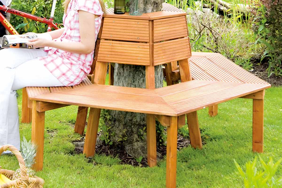 Houten boombank met rugleuning en tafelfunctie in de tuin met zittende persoon.
