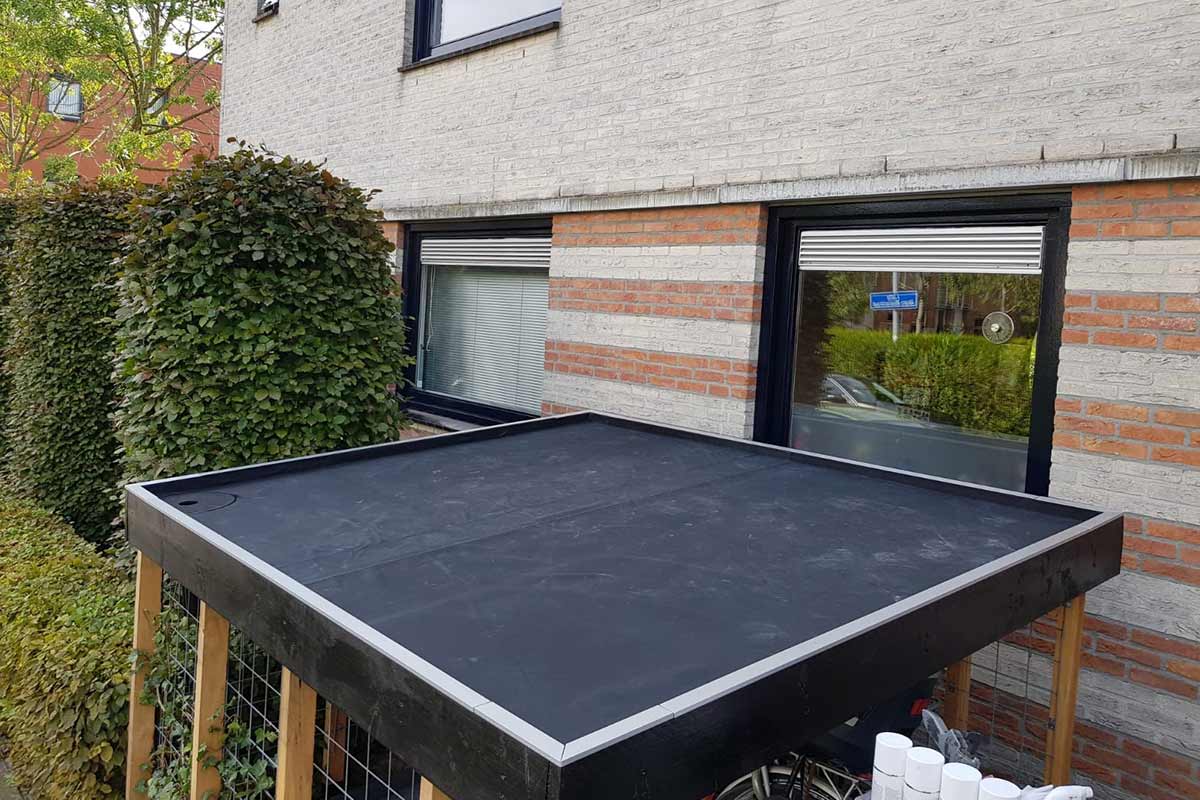 Houten fietsenstalling met plat dak bij het huis