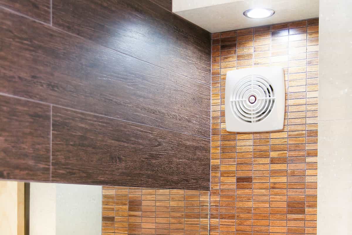 Badkamer met wandtegels in houtlook en ventilator