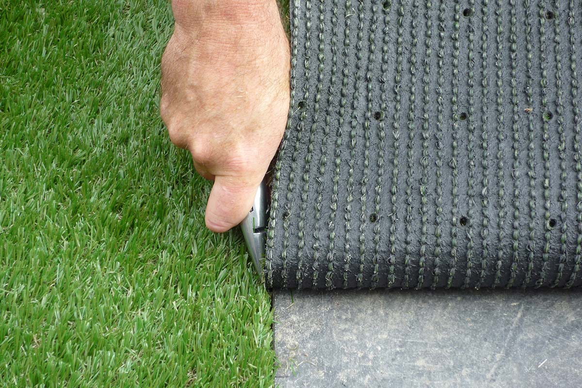Installatie van kunstgras met snijgereedschap