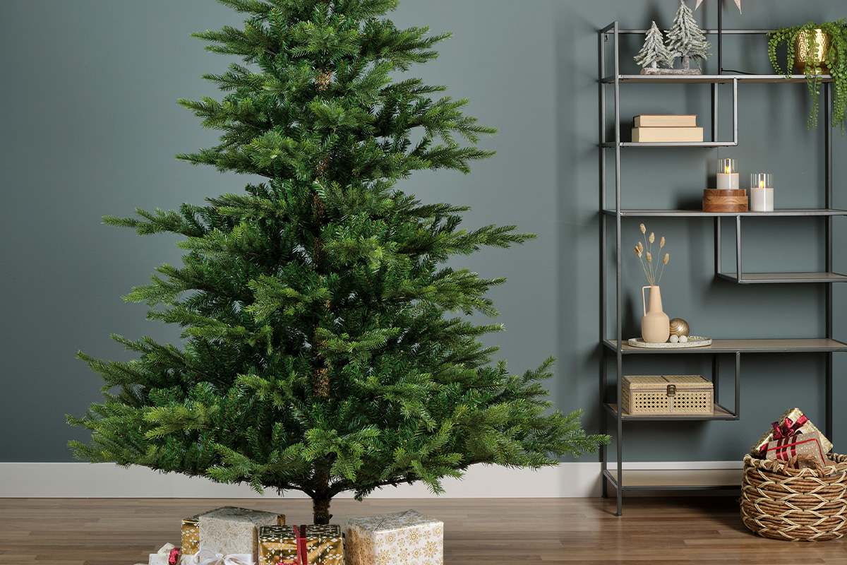 Versierde kerstboom met cadeaus en een rek op de achtergrond