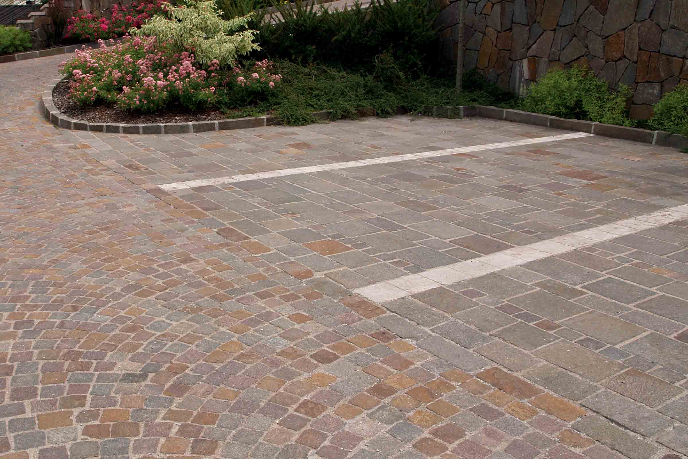 Bestrate oprit met verschillende steenpatronen en beplanting