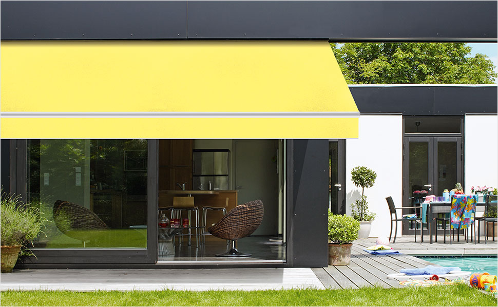 Geel zonnescherm aan een modern huis met terras en zwembad.