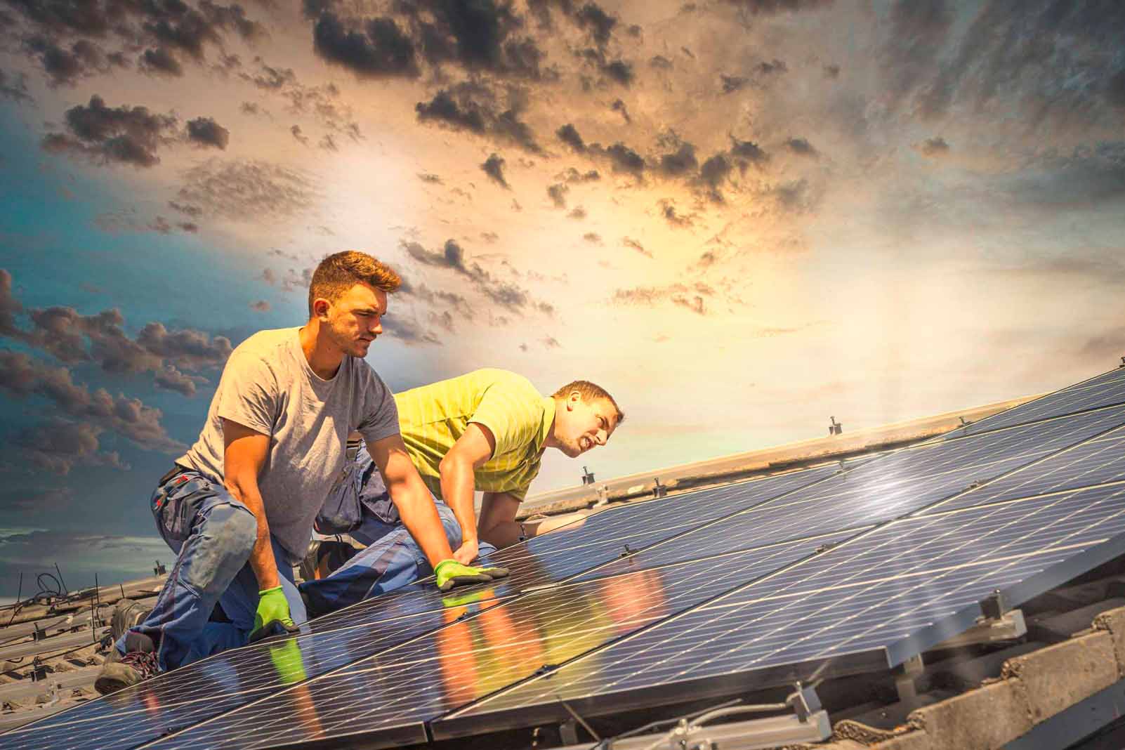 Twee monteurs installeren zonnepanelen op een dak.