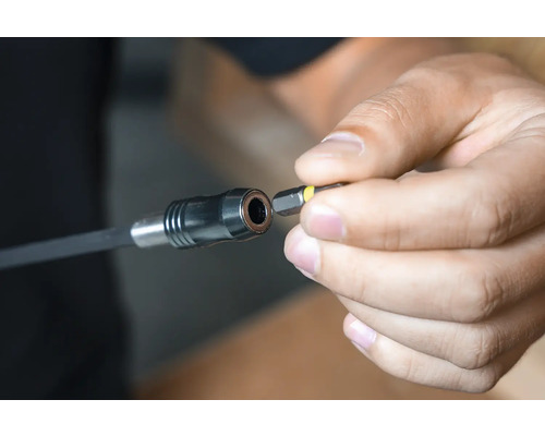 Een hand plaatst een schroefbit in een bithouder.