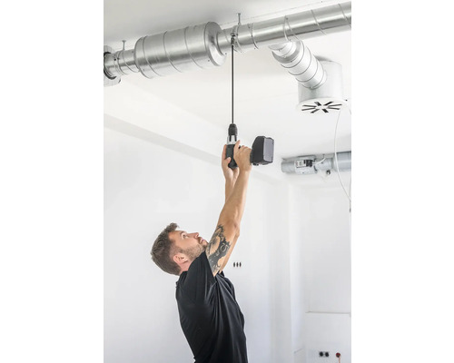 Man monteert ventilatiepijp met accuboormachine aan het plafond.