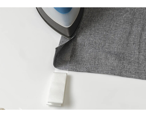 Strijkijzer op grijze stof met zoomvlies