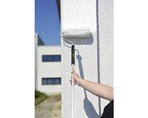 Een muur schilderen met een verfroller met telescopische steel
