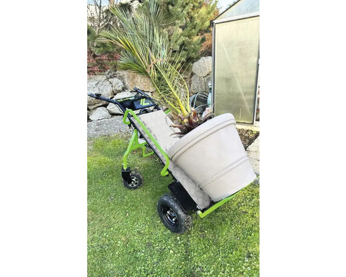 Kruiwagen met plant in pot in de tuin