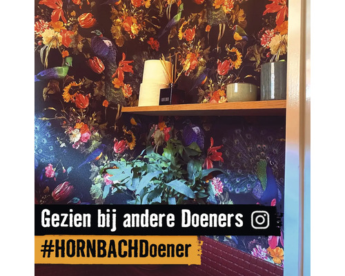 Decoratief behang met bloemmotieven en vogelafbeeldingen, gecombineerd met een houten plank en woonaccessoires.