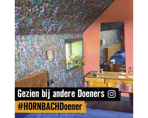 Slaapkamer met bloemenbehang op de muren en het plafond, raam, spiegel en commode.