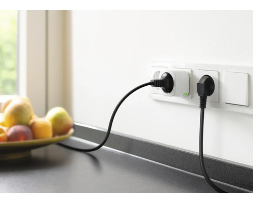 Stopcontacten met aangesloten stroomkabels aan een keukenmuur