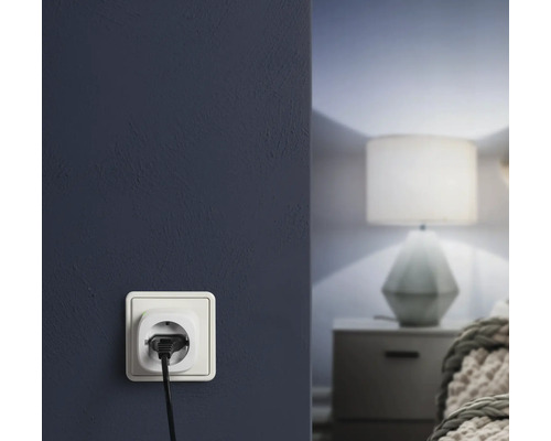 Stopcontact met stekker in een muur in de slaapkamer