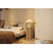 Gezellige slaapkamer met bed, nachtkastlamp en decoratieve elementen voor een ontspannen sfeer.