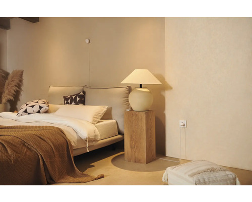 Gezellige slaapkamer met bed, nachtkastlamp en decoratieve elementen voor een ontspannen sfeer.