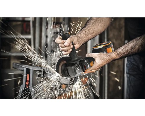 Man slijpt metaal met een draadloze haakse slijper, vonken vliegen eraf
