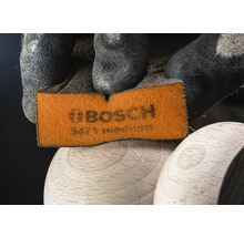 Bosch schuurpad wordt vastgehouden door een hand met beschermende handschoen