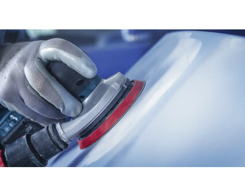 Close-up van een persoon die een oppervlak schuurt met een schuurmachine