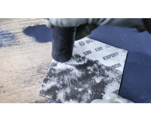 Schuren van een houten oppervlak met schuurpapier en schuurblok