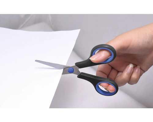 Een hand knipt papier met een schaar.