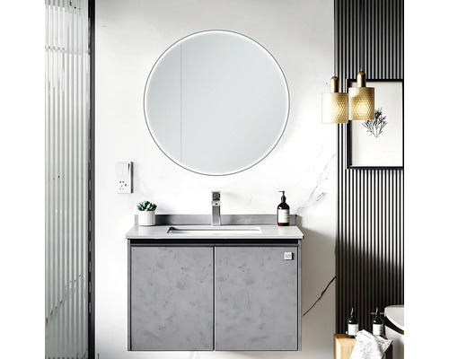 Moderne badkamer met wastafel, ronde spiegel met verlichting en decoratieve elementen.