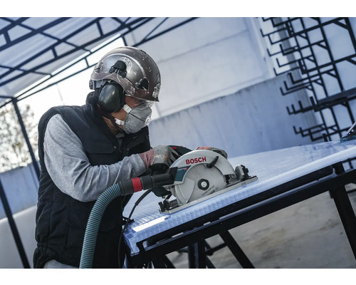 Vakman met beschermende kleding snijdt een kunststof plaat met een Bosch cirkelzaag.
