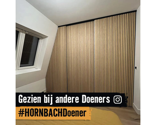 Houten panelen aan de wand in een kamer met een schuin dak en een raam