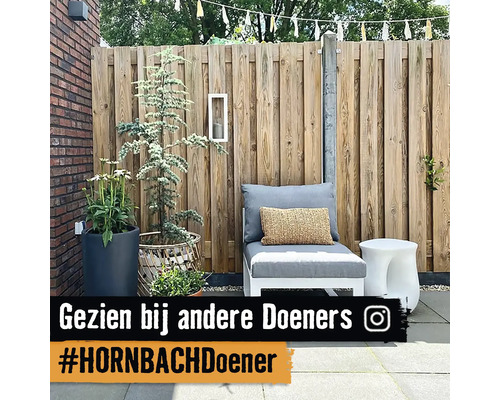 Terras met houten privacyscherm, fauteuil, bijzettafel en plantenbakken