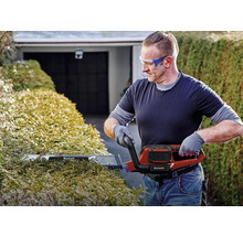 Man snoeit haag met een elektrische heggenschaar van Einhell.