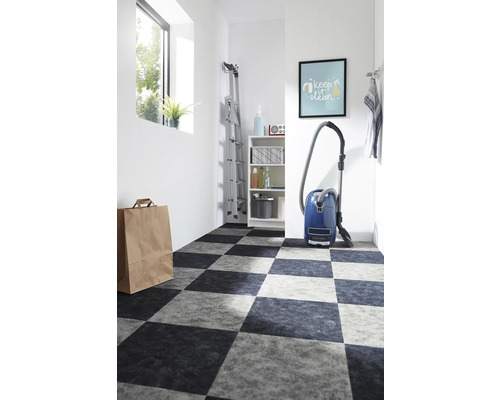 Lichte ruimte met schaakbordvloer, stofzuiger en ladder.