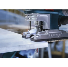 Close-up van een decoupeerzaag die een werkstuk snijdt.