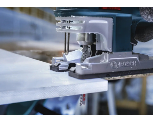 Close-up van een decoupeerzaag die een werkstuk snijdt.