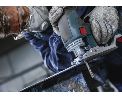 Man snijdt metaal met een decoupeerzaag. Hij draagt een veiligheidsbril, een ademhalingsmasker en handschoenen.