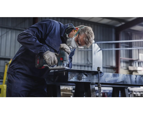 Ambachtsman met veiligheidsmasker en veiligheidsbril zaagt een werkstuk met een decoupeerzaag.