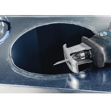 Een decoupeerzaag snijdt een gat in een metalen plaat.