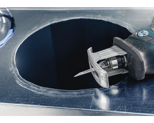 Een decoupeerzaag snijdt een gat in een metalen plaat.