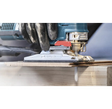 Close-up van een decoupeerzaag die hout snijdt, met handschoenen voor doe-het-zelvers.