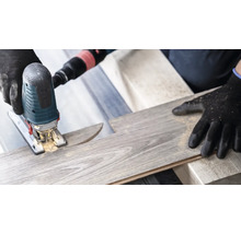 Een decoupeerzaag snijdt een laminaatplank.