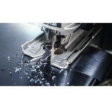 Decoupeerzaag snijdt metaal met metaalsplinters