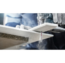 Een decoupeerzaag snijdt een houten werkstuk.