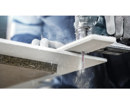 Een decoupeerzaag snijdt een houten werkstuk.