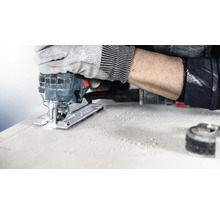 Een decoupeerzaag in gebruik bij het snijden van een werkstuk, bediend door iemand met werkhandschoenen.