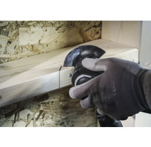 Een persoon zaagt een houten plank met een multifunctioneel gereedschap.