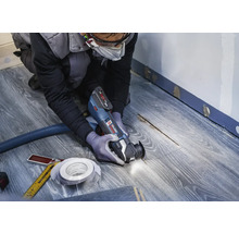 Ambachtsman gebruikt multifunctioneel gereedschap op laminaatvloer voor renovatiewerkzaamheden.