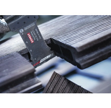 Bosch Logo. Close-up van een zaag die een terrasplank doorsnijdt.